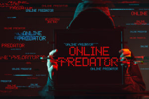 Hooded figure holding a screen that says “ONLINE PREDATOR” with glitch effects